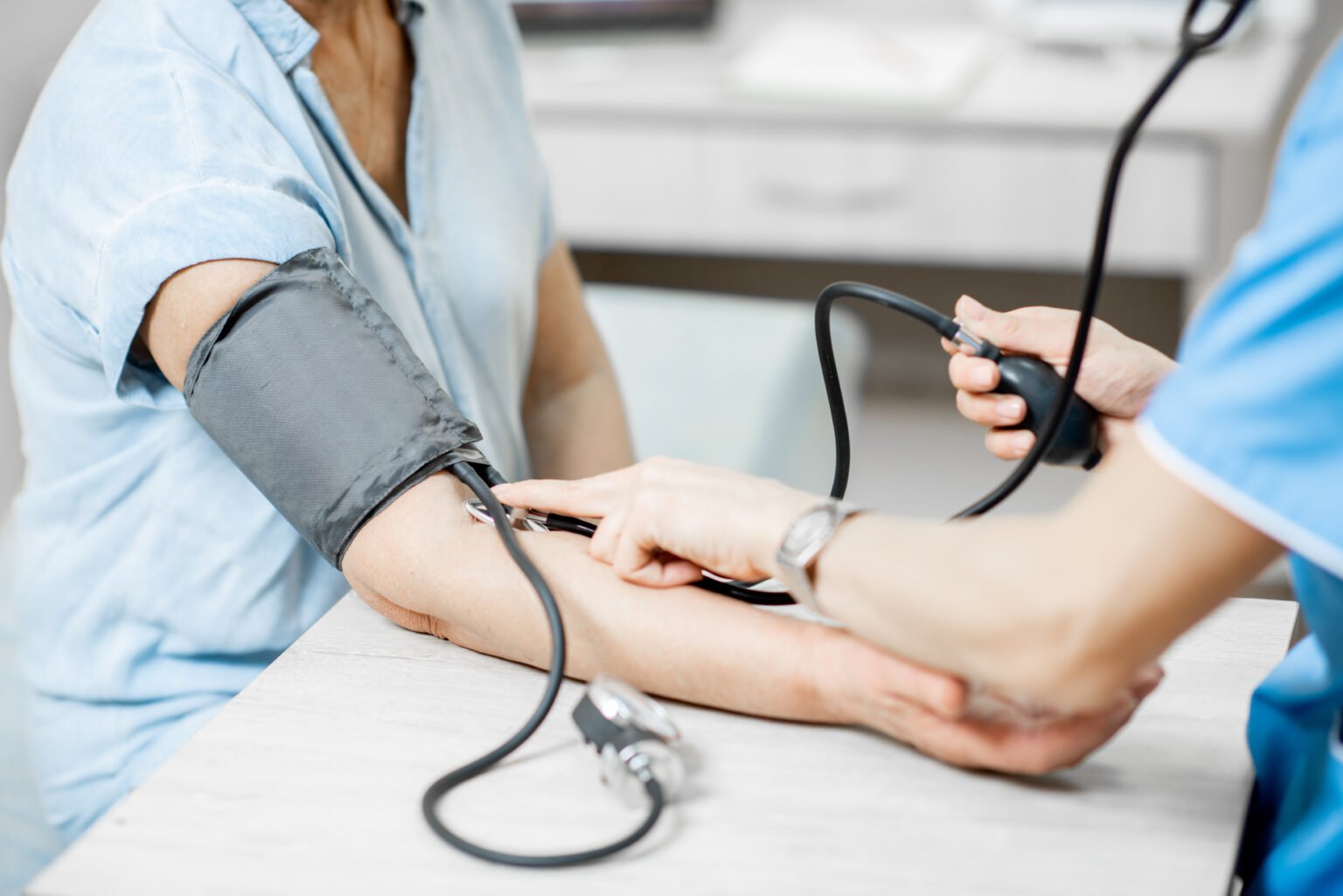 Una farmacéutica tomándole la tensión arterial a otra persona