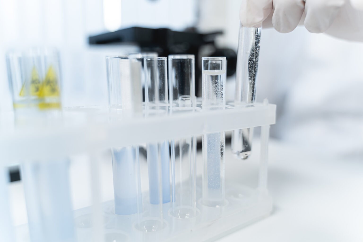 Tubos de ensayo de una persona en un laboratorio preparando una fórmula magistral