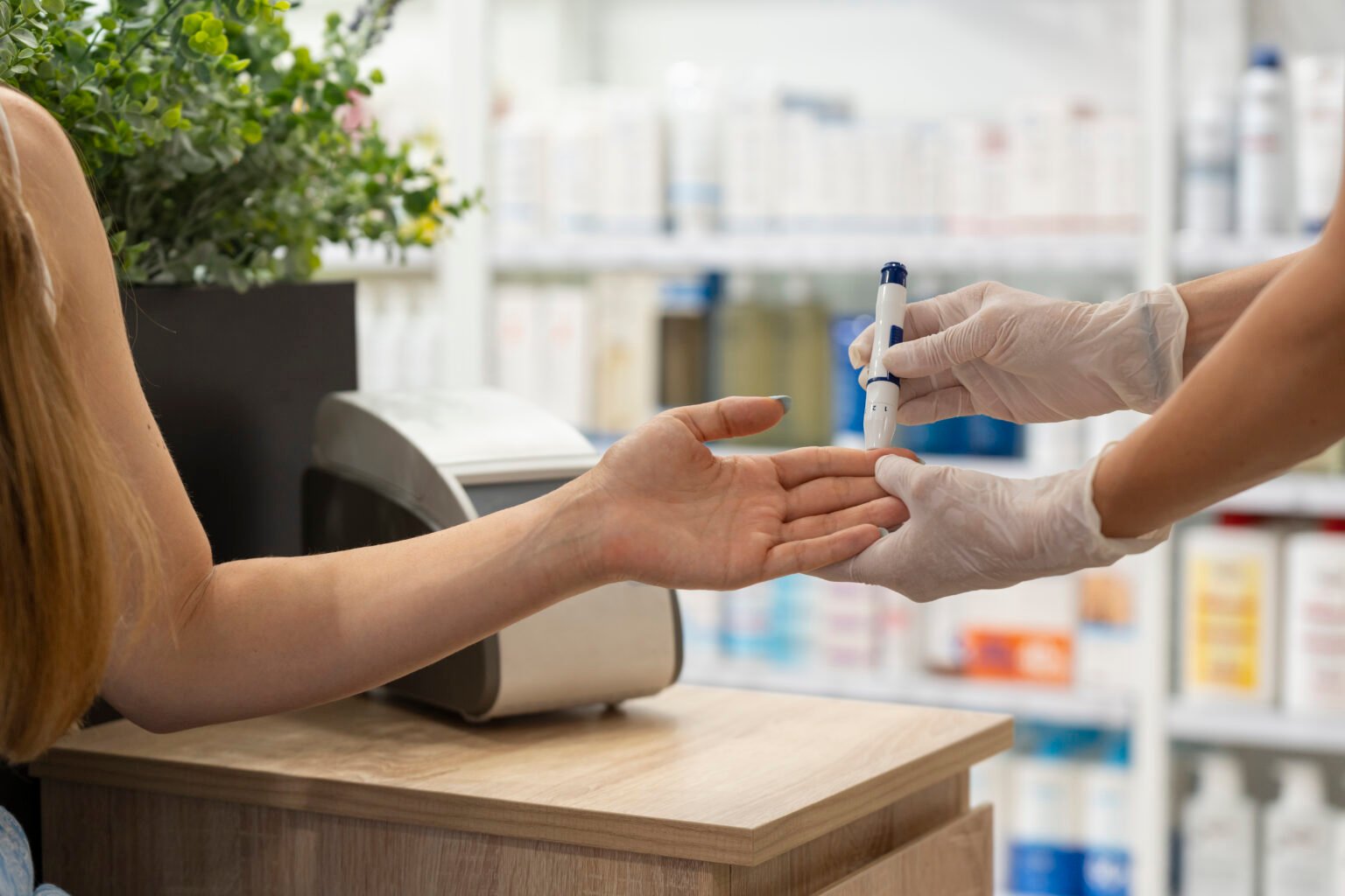Una farmacéutica haciéndole la prueba de la diabétes a otra persona